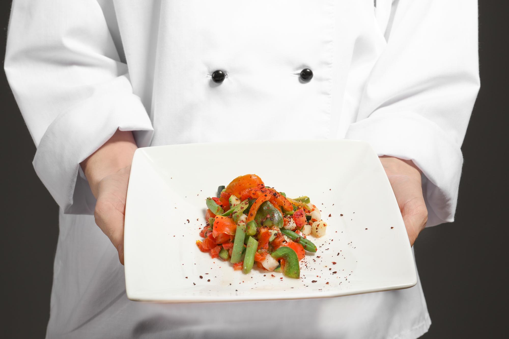 Chef prezentând o farfurie modernă cu ingrediente locale